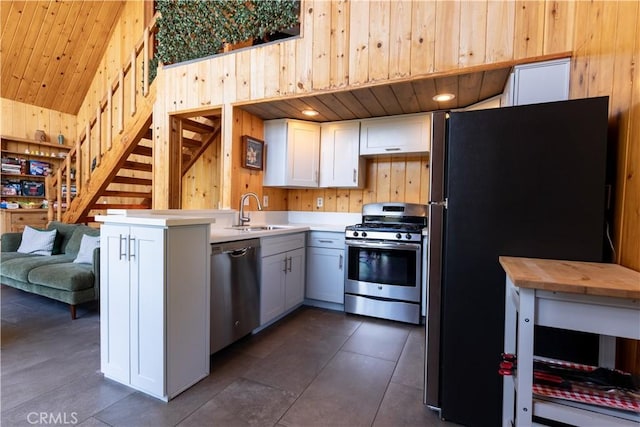 26503 Amador Ln, Lake Arrowhead, CA 92352 - kitchen with appliances with stainless steel finishes, a sink, wooden walls, a peninsula, and wood ceiling