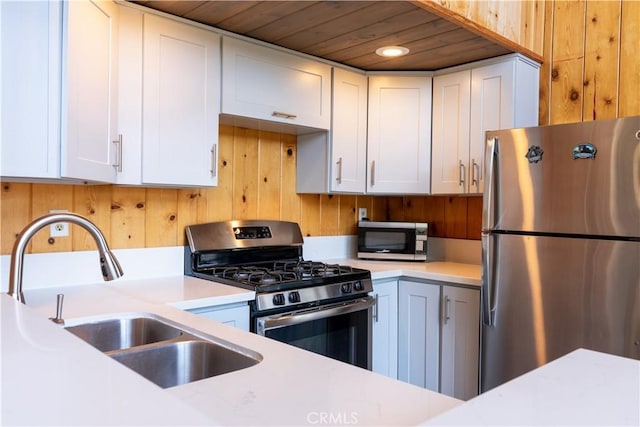 26503 Amador Ln, Lake Arrowhead, CA 92352 - kitchen featuring appliances with stainless steel finishes, a sink, light countertops, wood walls, and wooden ceiling