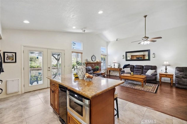 6752 Laurelbrook Dr, Riverside, CA 92506 - kitchen with lofted ceiling, a breakfast bar, light tile patterned floors, open floor plan, and a brick fireplace