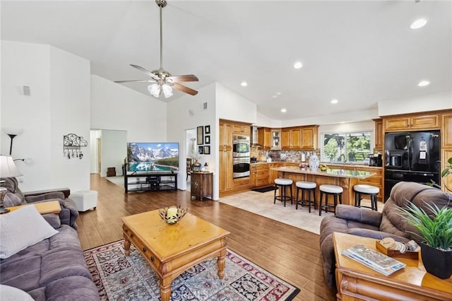 6752 Laurelbrook Dr, Riverside, CA 92506 - living area with light wood-style flooring, ceiling fan, high vaulted ceiling, and recessed lighting