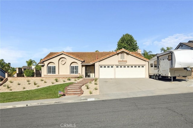 6752 Laurelbrook Dr, Riverside, CA 92506 - mediterranean / spanish-style home with a garage, stucco siding, a tiled roof, and concrete driveway