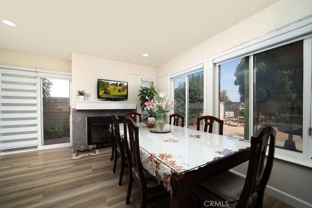 6678 Wrangler Rd, Chino Hills, CA 91709 - dining area featuring healthy amount of natural light, a glass covered fireplace, wood finished floors, and recessed lighting