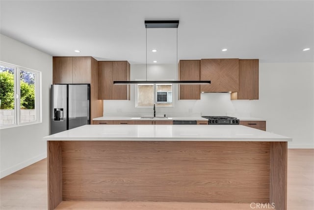 11240 Lull St, Sun Valley, CA 91352 - kitchen featuring stainless steel fridge, modern cabinets, brown cabinetry, baseboards, and recessed lighting