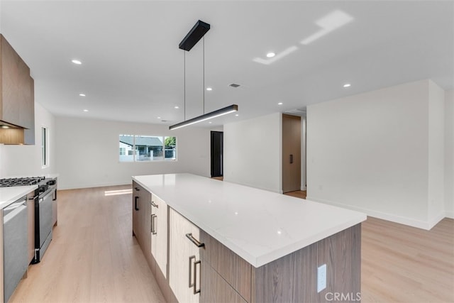 11240 Lull St, Sun Valley, CA 91352 - kitchen with modern cabinets, black gas range, light wood-style floors, open floor plan, and recessed lighting