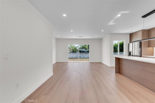 11240 Lull St, Sun Valley, CA 91352 - unfurnished living room featuring plenty of natural light, recessed lighting, light wood-style flooring, and baseboards
