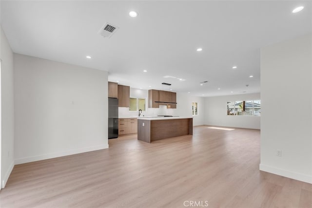 11240 Lull St, Sun Valley, CA 91352 - unfurnished living room with light wood-type flooring, recessed lighting, baseboards, and a sink