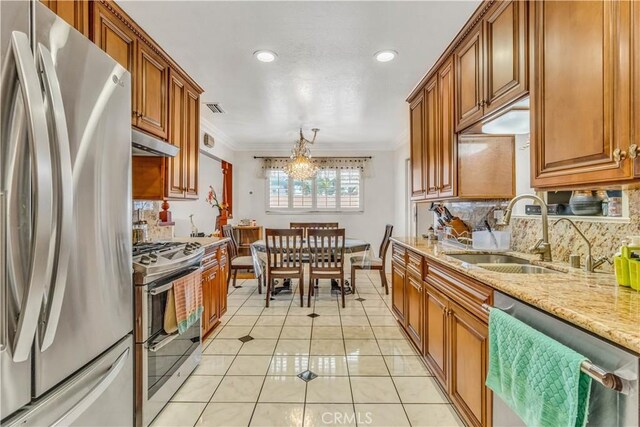 15112 Alderpoint Dr, La Mirada, CA 90638 - kitchen featuring appliances with stainless steel finishes, under cabinet range hood, crown molding, backsplash, and brown cabinetry