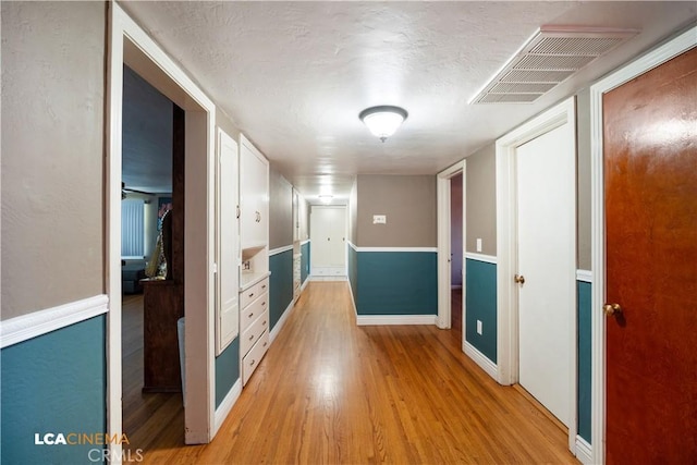 13271 Garzoli Ave, Mcfarland, CA 93250 - hallway with light wood finished floors, baseboards, and a textured ceiling