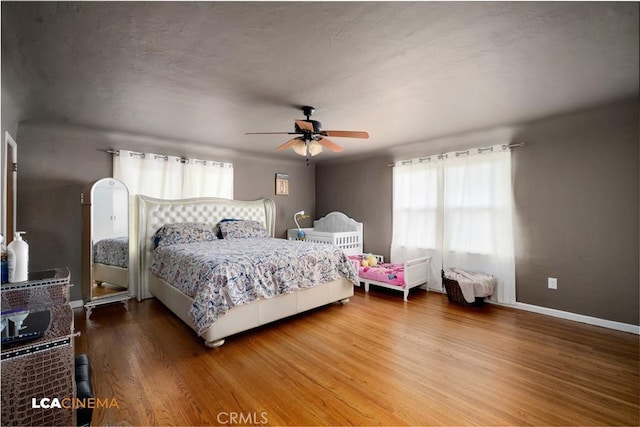 13271 Garzoli Ave, Mcfarland, CA 93250 - bedroom with multiple windows, wood finished floors, baseboards, and a ceiling fan