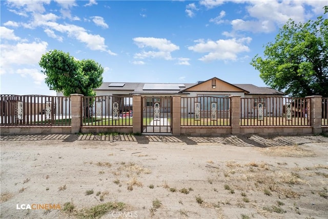 13271 Garzoli Ave, Mcfarland, CA 93250 - rear view of property featuring solar panels, a fenced front yard, and a gate