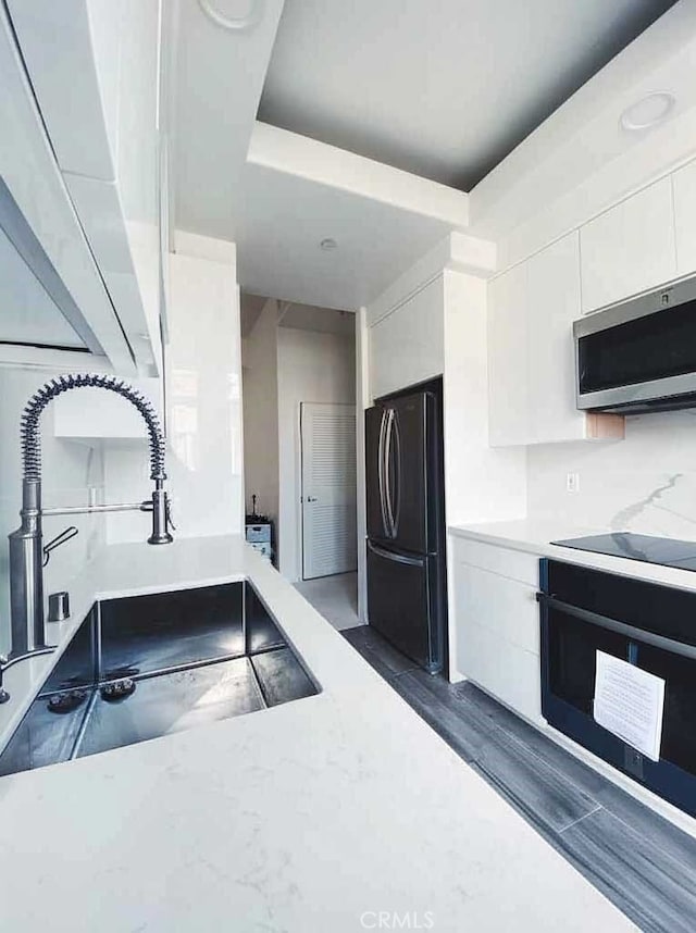 144 S 3rd St Unit 535, San Jose, CA 95112 - kitchen featuring black appliances, a sink, white cabinets, light countertops, and modern cabinets