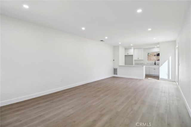 4708 Sunrise Rdg, Oceanside, CA 92056 - unfurnished living room featuring recessed lighting, light wood finished floors, baseboards, and a sink