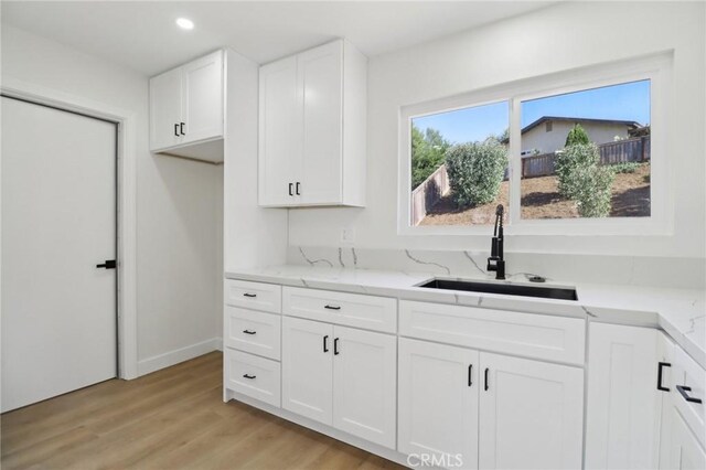 4708 Sunrise Rdg, Oceanside, CA 92056 - kitchen with a sink, light stone countertops, white cabinetry, light wood-style floors, and recessed lighting