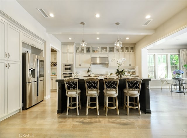 46 Shadybend, Irvine, CA 92602 - kitchen with appliances with stainless steel finishes, under cabinet range hood, backsplash, an island with sink, and recessed lighting