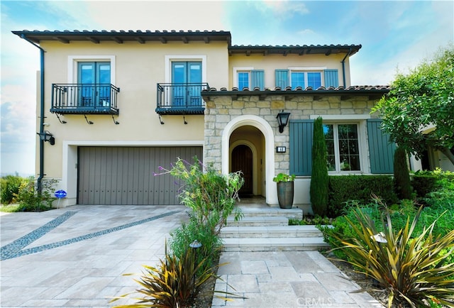 46 Shadybend, Irvine, CA 92602 - mediterranean / spanish house featuring a balcony, concrete driveway, an attached garage, stucco siding, and stone siding