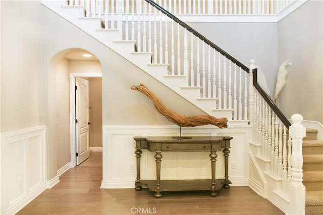 46 Shadybend, Irvine, CA 92602 - stairway featuring a high ceiling, wood finished floors, and arched walkways