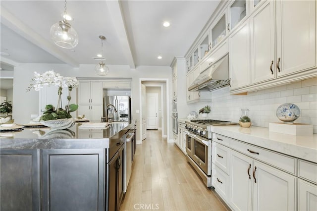 46 Shadybend, Irvine, CA 92602 - kitchen with appliances with stainless steel finishes, beam ceiling, decorative backsplash, under cabinet range hood, and an island with sink
