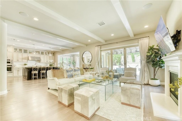 46 Shadybend, Irvine, CA 92602 - living area with beamed ceiling, light wood finished floors, a glass covered fireplace, and recessed lighting