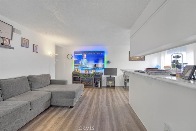 3441 20th St, Highland, CA 92346 - living area featuring wood finished floors, a textured ceiling, and baseboards