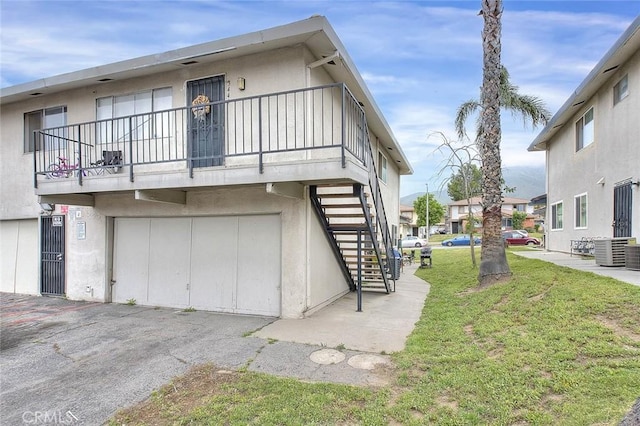 3441 20th St, Highland, CA 92346 - view of home's exterior with stairs, a lawn, a balcony, a garage, and stucco siding