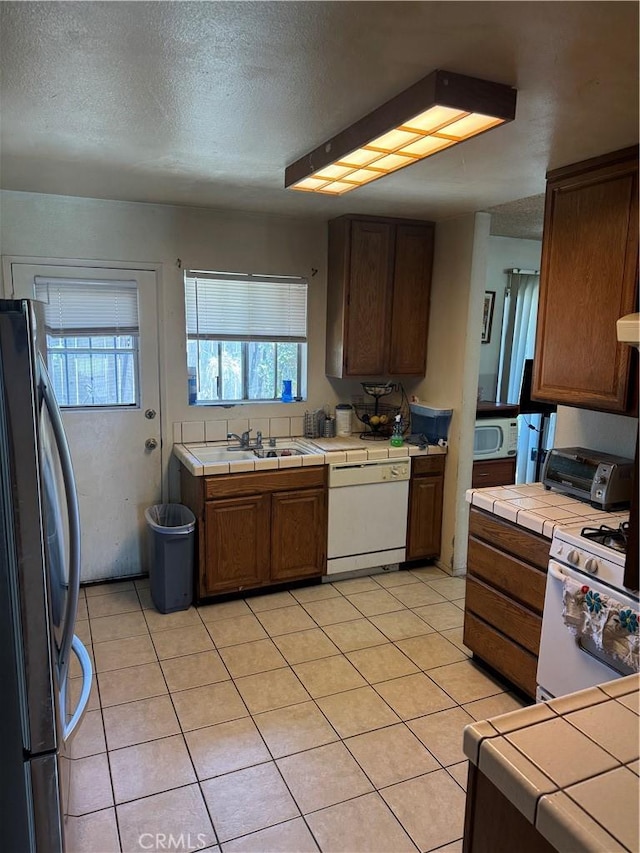 14222 Filmore St, Arleta, CA 91331 - kitchen featuring white appliances, tile counters, a textured ceiling, and light tile patterned floors