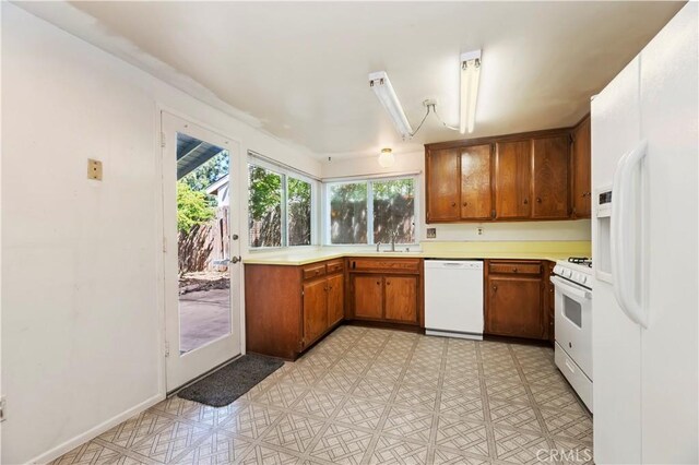 42769 Tierra Robles Pl, Temecula, CA 92592 - kitchen featuring white appliances, brown cabinetry, light countertops, light floors, and a sink
