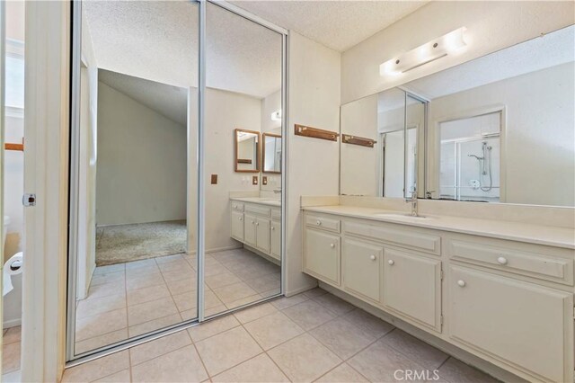 42769 Tierra Robles Pl, Temecula, CA 92592 - full bathroom with vanity, a textured ceiling, a shower stall, and tile patterned flooring