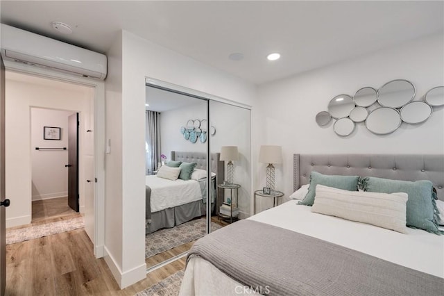 5700 Ravenspur Dr Unit 307, Rancho Palos Verdes, CA 90275 - bedroom with a wall unit AC, wood finished floors, a closet, baseboards, and recessed lighting
