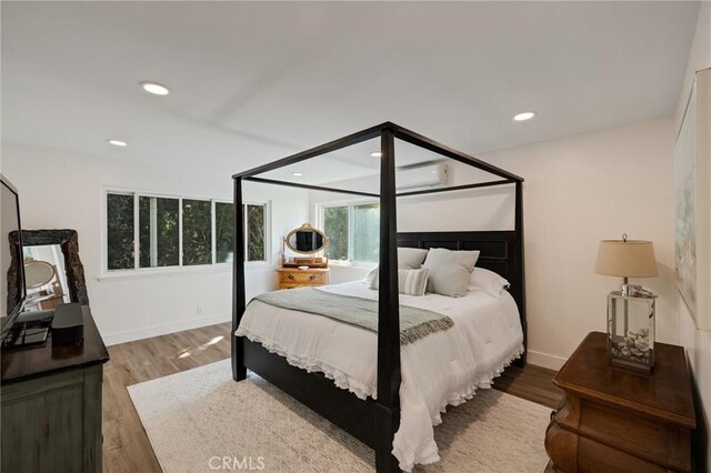 5700 Ravenspur Dr Unit 307, Rancho Palos Verdes, CA 90275 - bedroom with wood finished floors, recessed lighting, a wall unit AC, and baseboards