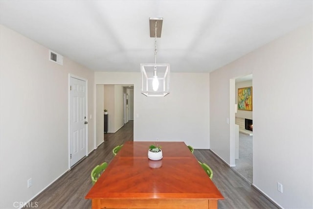 1326 Rosehill Dr, Riverside, CA 92507 - dining area featuring dark wood-style flooring and a warm lit fireplace
