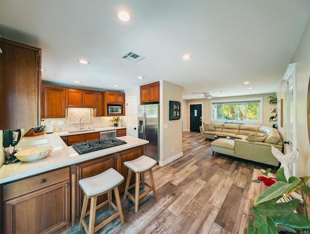 8635 La Butte Ln, Santee, CA 92071 - kitchen featuring stainless steel appliances, a sink, light countertops, a peninsula, and wood finished floors