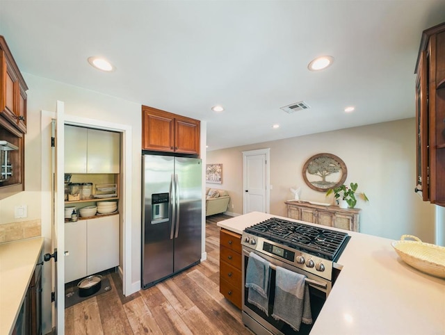 8635 La Butte Ln, Santee, CA 92071 - kitchen featuring stainless steel appliances, light countertops, light wood finished floors, brown cabinetry, and recessed lighting