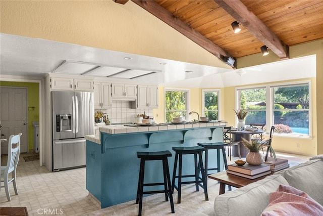 558 Paseo Companeros St, Chico, CA 95928 - kitchen featuring stainless steel refrigerator with ice dispenser, tile countertops, a breakfast bar area, plenty of natural light, and wooden ceiling
