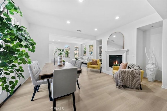97 Twin Gables, Irvine, CA 92620 - dining area with light wood-type flooring, recessed lighting, a glass covered fireplace, built in features, and baseboards