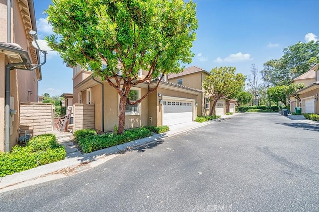 97 Twin Gables, Irvine, CA 92620 - view of front facade featuring stucco siding, a residential view, and an attached garage