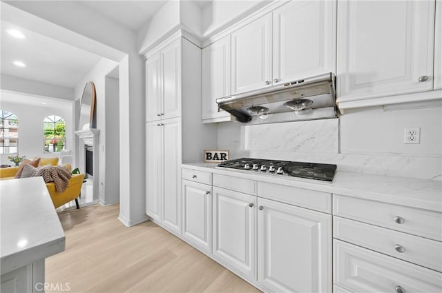 97 Twin Gables, Irvine, CA 92620 - kitchen featuring under cabinet range hood, light countertops, light wood-style flooring, white cabinets, and stainless steel gas cooktop