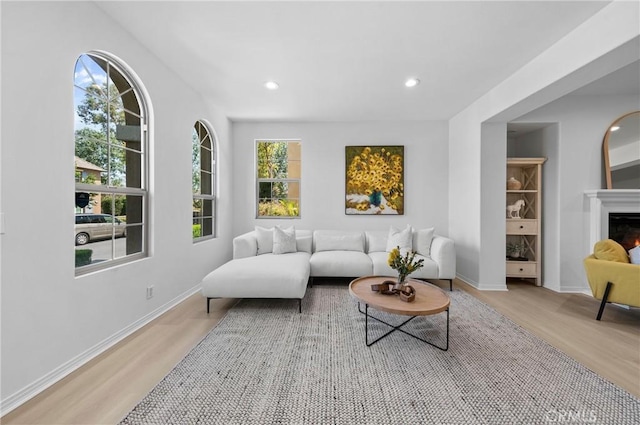 97 Twin Gables, Irvine, CA 92620 - living area with light wood-style flooring, a lit fireplace, recessed lighting, and baseboards