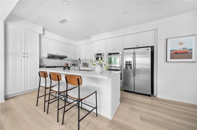 97 Twin Gables, Irvine, CA 92620 - kitchen with appliances with stainless steel finishes, light wood-type flooring, white cabinets, and recessed lighting