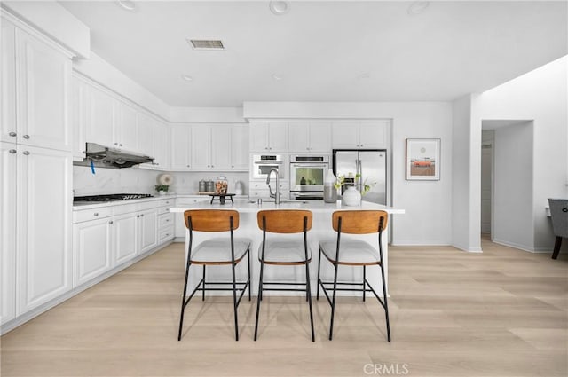 97 Twin Gables, Irvine, CA 92620 - kitchen with a kitchen breakfast bar, light wood-style flooring, light countertops, and white cabinetry