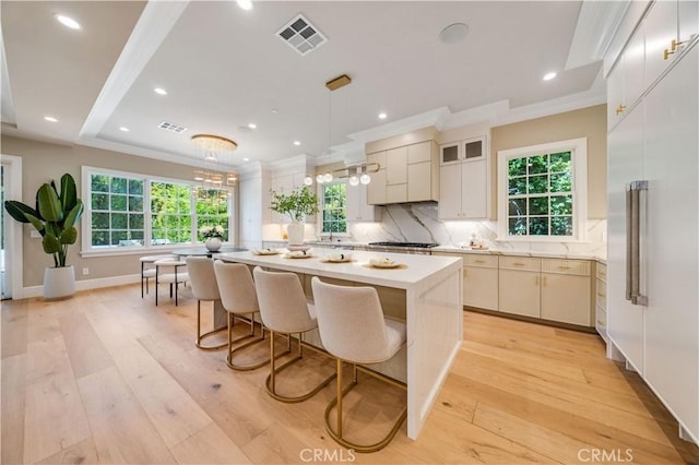 608 Arbolada Dr, Arcadia, CA 91006 - kitchen featuring light countertops, healthy amount of natural light, a center island, crown molding, and decorative backsplash