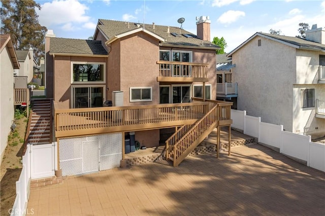 23801 Birch Ln, Mission Viejo, CA 92691 - back of property featuring stairs, stucco siding, a chimney, and a wooden deck