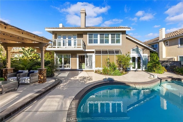 2712 N Roxbury St, Orange, CA 92867 - rear view of house with a balcony, french doors, a patio area, and an outdoor pool