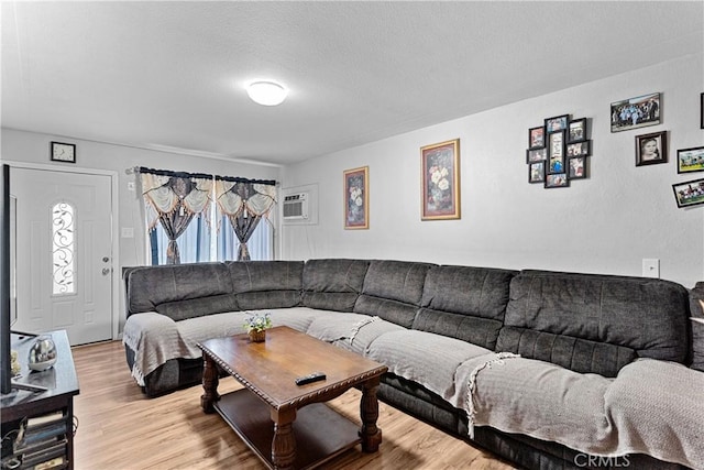 4776 E Lowe Ave, Fresno, CA 93702 - living room with light wood-type flooring, a textured ceiling, and a wall mounted AC