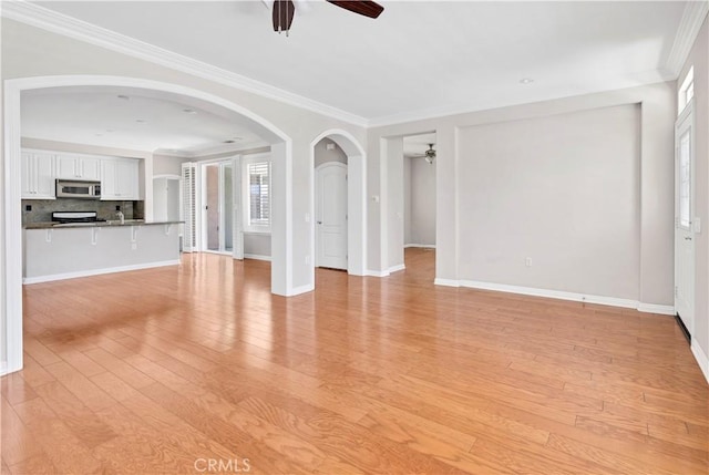 243 Firestone, Hemet, CA 92545 - unfurnished living room with ceiling fan, light wood-style floors, ornamental molding, baseboards, and arched walkways