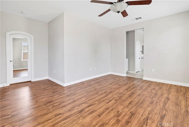 243 Firestone, Hemet, CA 92545 - empty room featuring arched walkways, a ceiling fan, and wood finished floors
