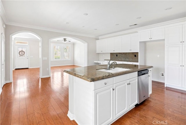 243 Firestone, Hemet, CA 92545 - kitchen featuring a sink, dishwasher, arched walkways, dark stone counters, and decorative backsplash