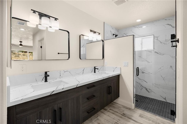 9641 Buena Vista St, Apple Valley, CA 92308 - bathroom featuring a marble finish shower, double vanity, a ceiling fan, baseboards, and wood finished floors