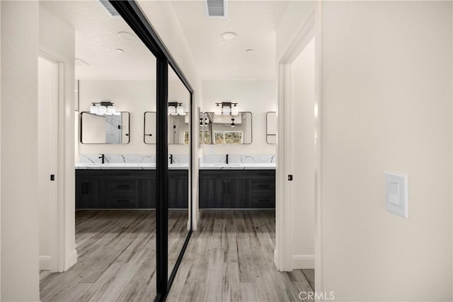 9641 Buena Vista St, Apple Valley, CA 92308 - bathroom featuring double vanity, wood finished floors, and baseboards
