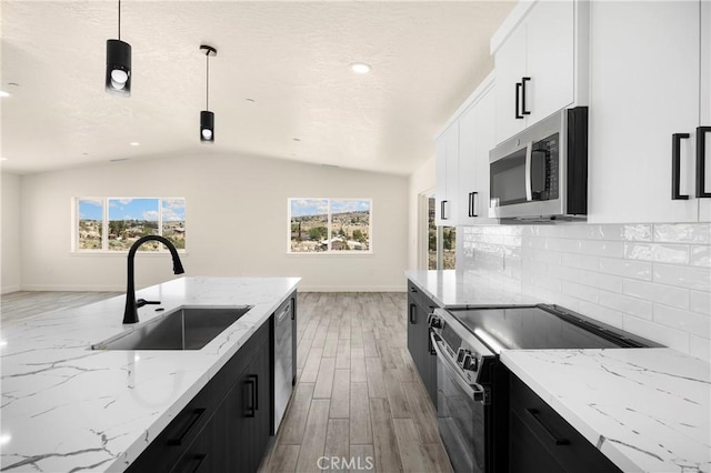 9641 Buena Vista St, Apple Valley, CA 92308 - kitchen featuring appliances with stainless steel finishes, a sink, dark cabinetry, baseboards, and vaulted ceiling