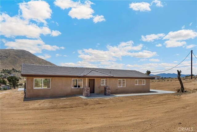 9641 Buena Vista St, Apple Valley, CA 92308 - back of property featuring a mountain view, a tiled roof, a patio area, and stucco siding